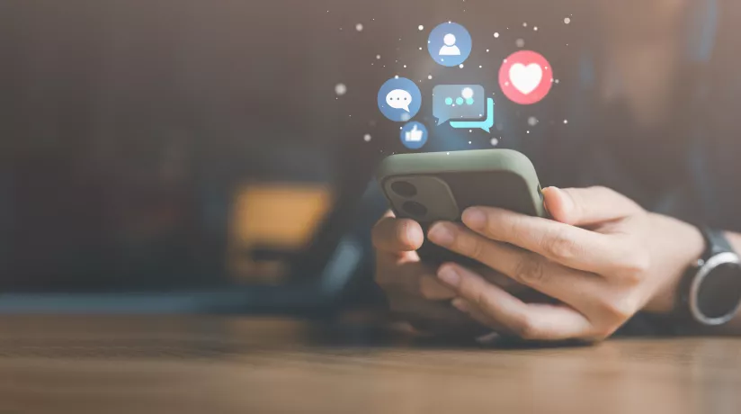 hands scrolling on a phone and social media icons